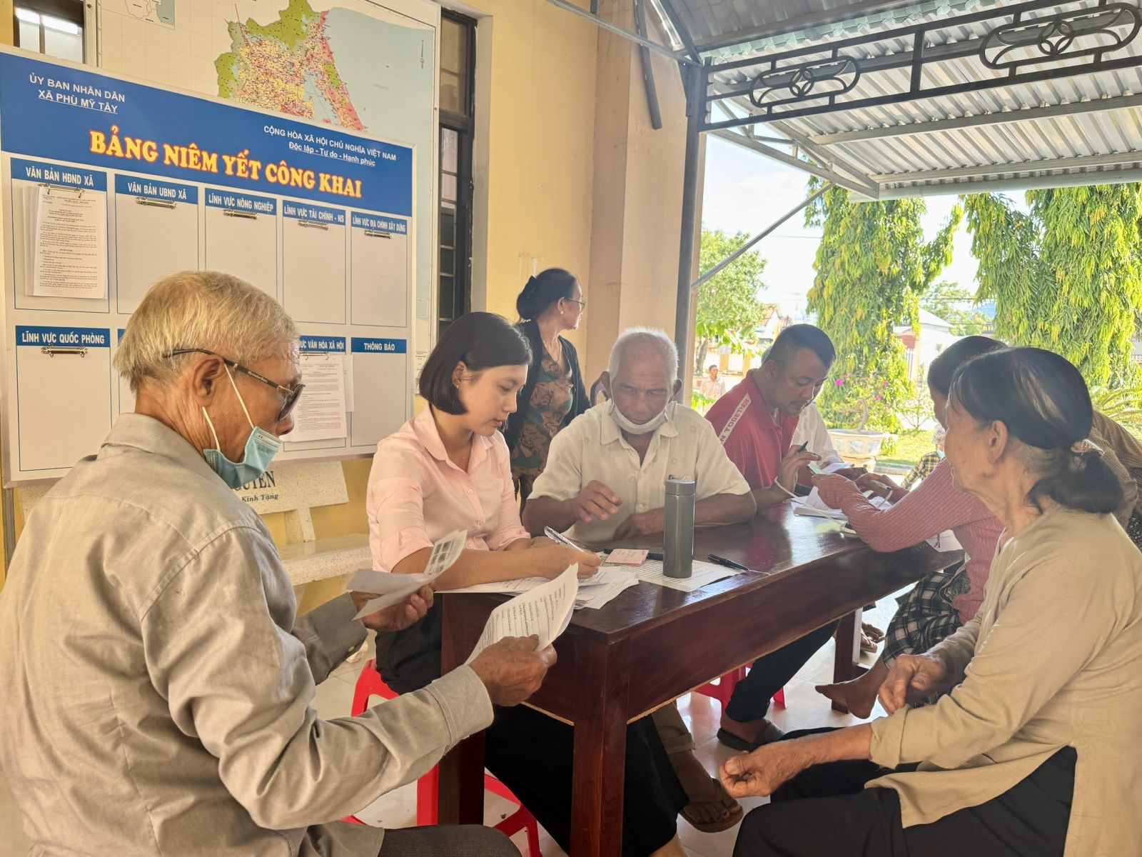 Cán bộ Phòng Văn hóa xã hội xã Phù Mỹ Tây hướng dẫn người dân xác lập hồ sơ đề nghị hưởng trợ cấp hưu trí xã hội hàng tháng